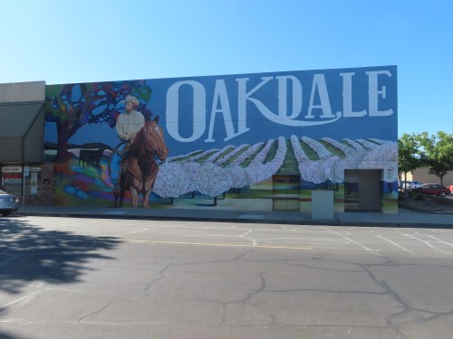 A colorful mural featuring a cowboy on a horse and the word "OAKDALE," with fields in the background.