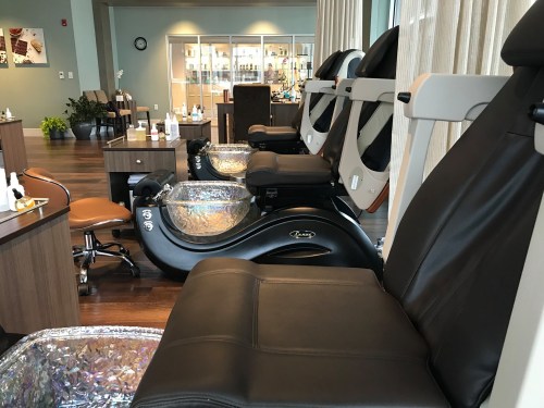 Interior of a spa with several pedicure chairs and foot baths, featuring a modern and relaxing atmosphere.