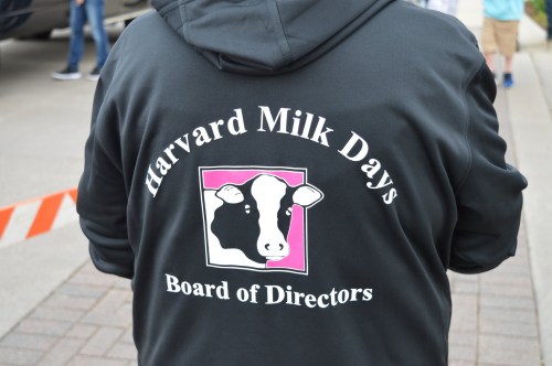 A person wearing a black hoodie with "Harvard Milk Days Board of Directors" and a cow graphic on the back.
