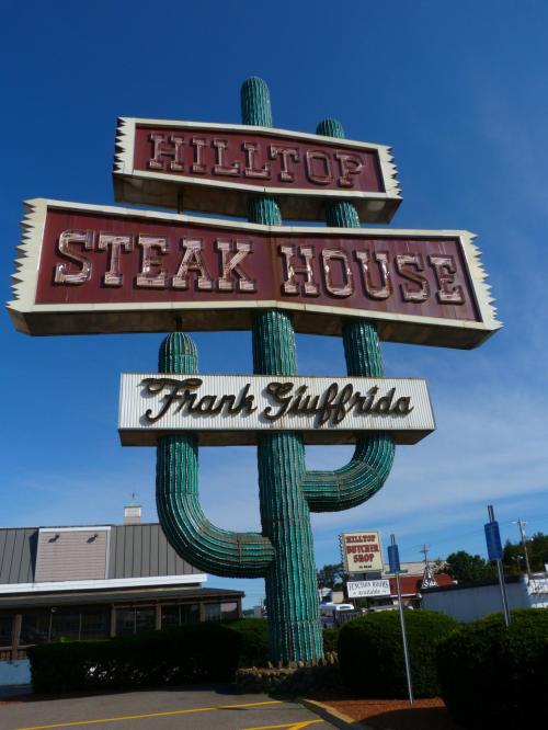 Sign for Hilltop Steak House featuring a large cactus design, with the name "Frank Gifford" prominently displayed.