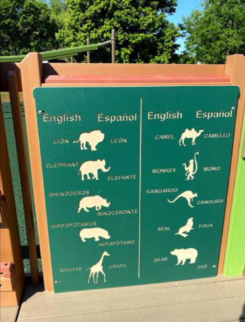 Sign displaying animal names in English and Spanish, including lion, elephant, giraffe, and more.