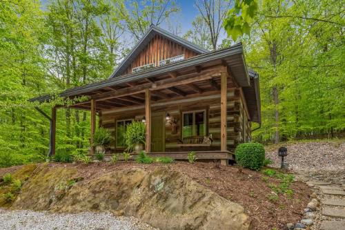A charming log cabin surrounded by lush greenery, featuring a welcoming porch and rustic wooden details.