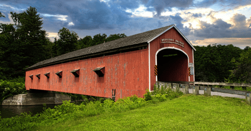 A red covered bridge on a cloudy day in New York State.