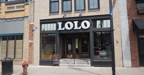Exterior of a restaurant named "LOLO," featuring large windows and a welcoming entrance with an open sign.