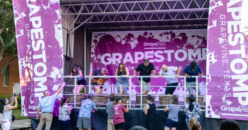 Participants compete in a grape-stomping contest on stage at the Grapefest event in Grapevine, Texas.