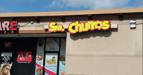 Sign for "Sra. Churros" on a storefront, featuring bright colors and a casual design.