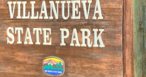Sign for Villanueva State Park, featuring wooden texture and colorful emblem of New Mexico State Parks.