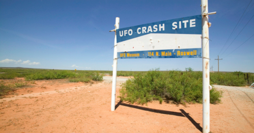 Sign for the UFO Crash Site in Roswell, New Mexico, surrounded by desert landscape and blue sky.