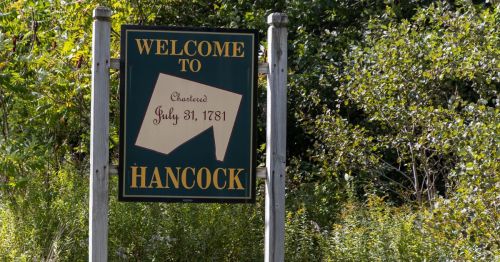 A welcome sign for Hancock, featuring the date "Chartered July 31, 1781," surrounded by greenery.