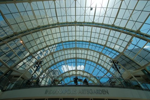 View of the Indianapolis Artsgarden's glass ceiling, showcasing blue skies and modern architecture.