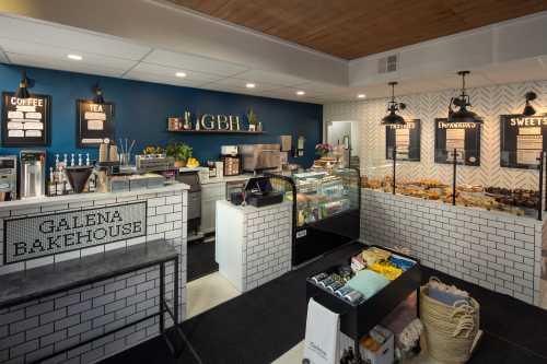 A cozy bakery interior featuring a display case of pastries, coffee station, and a welcoming atmosphere.