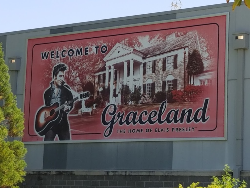 Sign welcoming visitors to Graceland, featuring an image of Elvis Presley and the iconic mansion.