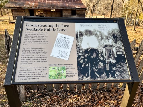 Sign about homesteading public land, featuring historical text and images, with a rustic cabin in the background.