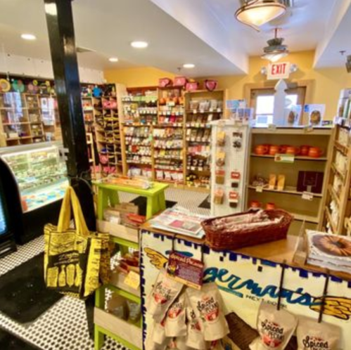 A cozy shop interior filled with shelves of snacks, spices, and treats, featuring a colorful display and a vintage freezer.