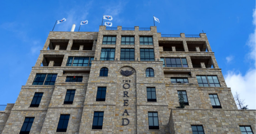 The Oread hotel building with stone facade and flags against a blue sky.
