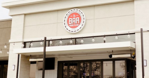 Exterior of a restaurant named "The BAA" with a circular sign and string lights above the entrance.
