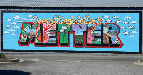 Colorful mural featuring the phrase "Everything's better in Moultrie" with various local images and symbols.