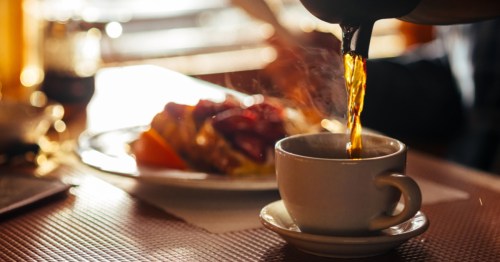A fresh cup of coffee being poured at an old-school diner table.