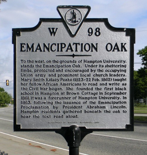 Sign marking the Emancipation Oak at Hampton University, honoring its historical significance in education and emancipation.
