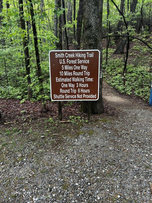 Sign for Smith Creek Hiking Trail, detailing distances, estimated walking times, and shuttle service information.