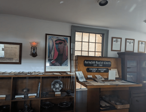 Interior of a museum displaying historical documents and artifacts, including a Morehouse College poster and church history.