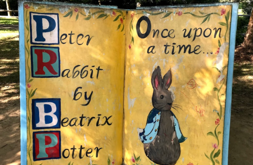 A colorful storybook display featuring "Peter Rabbit" by Beatrix Potter, with an illustration of a rabbit.