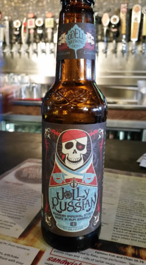 A bottle of Jolly Russian beer from Odell Brewing Co., featuring a colorful label with a skull and matryoshka design.