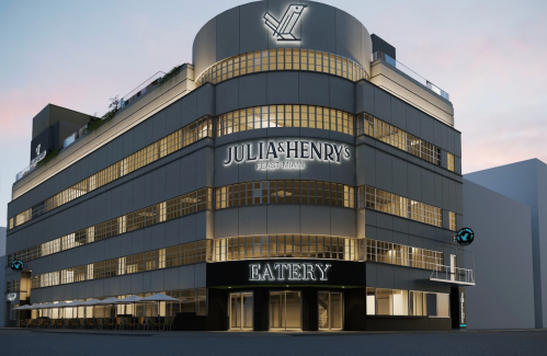 A modern building featuring "Julia & Henry's Eatery" signage, with a sleek design and illuminated exterior.