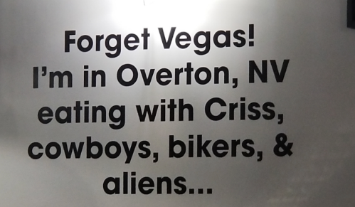 Text on a wall: "Forget Vegas! I’m in Overton, NV eating with Criss, cowboys, bikers, & aliens..."