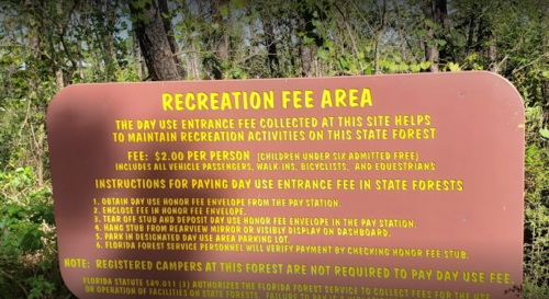 Sign detailing recreation fee area instructions and payment information for a state forest. Fee: $2 per person.