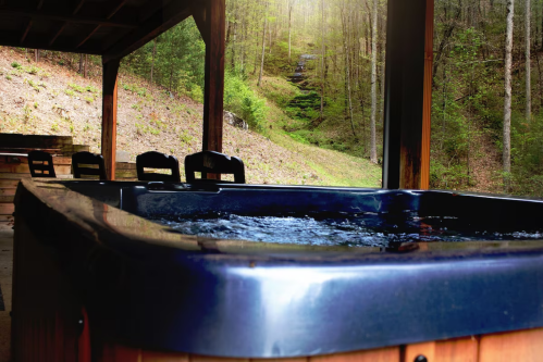 A hot tub on a wooden deck surrounded by trees and a serene, natural landscape.