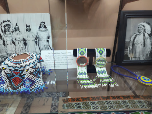 Display of traditional Native American jewelry and artifacts, including beaded items and historical photographs.