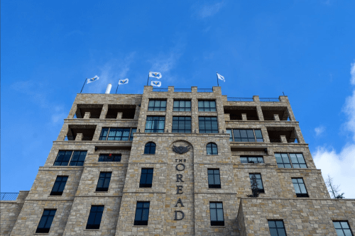 A tall stone building with flags on top, featuring the name "The Oread" prominently displayed on the facade.