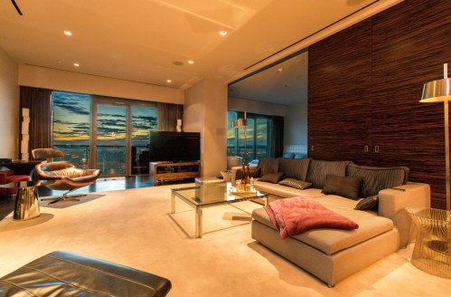 Modern living room with large windows, stylish furniture, and a sunset view. Cozy and elegant atmosphere.