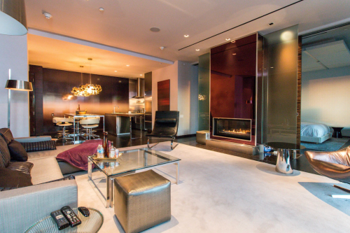 Modern living space featuring a sleek kitchen, cozy seating area, and a stylish fireplace. Bright and spacious design.