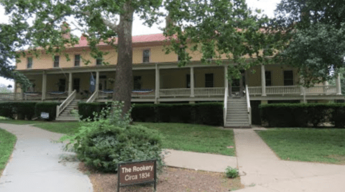 Historic building with a porch, surrounded by greenery, labeled "The Rookery, Circa 1894."