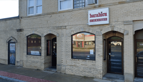 Exterior of a brick building featuring the sign for "Barabicu Smokehouse" and large windows.