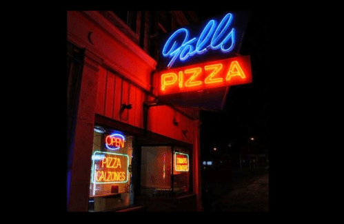 Neon signs for "Falls Pizza" and "Open" illuminate a storefront at night.
