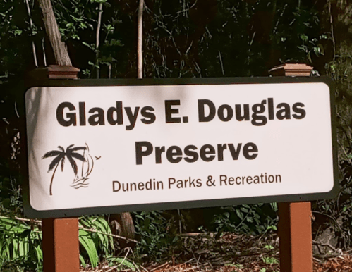 Sign for Gladys E. Douglas Preserve, featuring palm trees and indicating Dunedin Parks & Recreation.