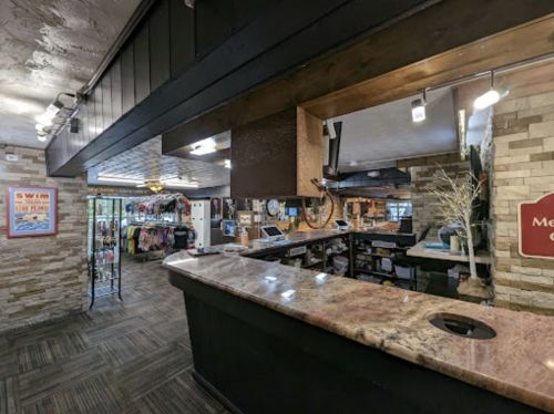 Interior view of a reception area with a stone and wood design, featuring a counter and merchandise display.