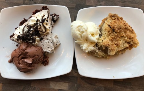 Two dessert plates: one with chocolate ice cream, whipped cream, and cake; the other with apple crumble and vanilla ice cream.