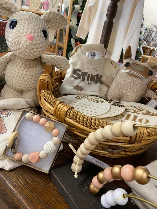 A cozy display featuring a crocheted bunny, a woven basket, and various decorative items, including a beaded bracelet.