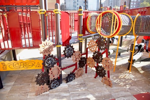Colorful playground equipment featuring climbing structures and interactive elements in a sunny outdoor setting.