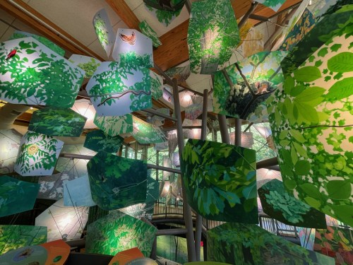 A vibrant display of hanging panels depicting lush greenery and wildlife, creating an immersive nature experience.