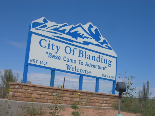 Welcome sign for the City of Blanding, featuring mountains and the text "Base Camp To Adventure," established in 1905.