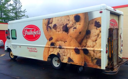 A delivery truck featuring a large image of chocolate chip cookies and the Freihofers logo.