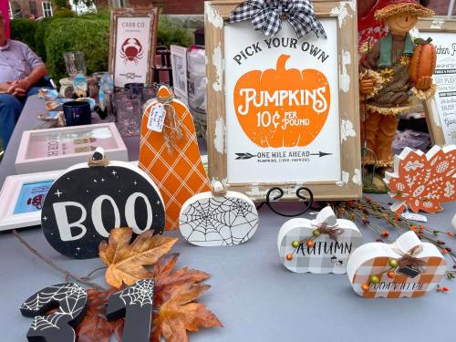 A display of decorative pumpkins and autumn-themed signs, including "Pick Your Own Pumpkins" and "Boo."