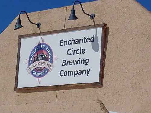 Sign for Enchanted Circle Brewing Company, featuring a logo with mountains and the text "Handcrafted Beer."