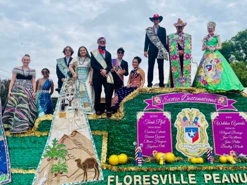 A colorful parade float featuring participants in festive attire, celebrating with crowns and sashes.