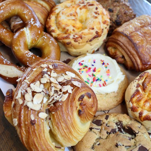 A variety of baked goods including pretzels, pastries, and cookies arranged on a platter.